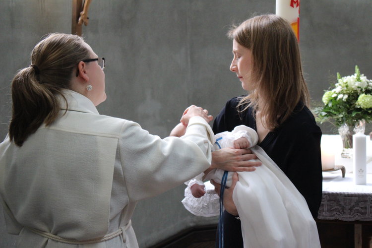 pappi siunaa lapsen pyhällä ristinmerkillä